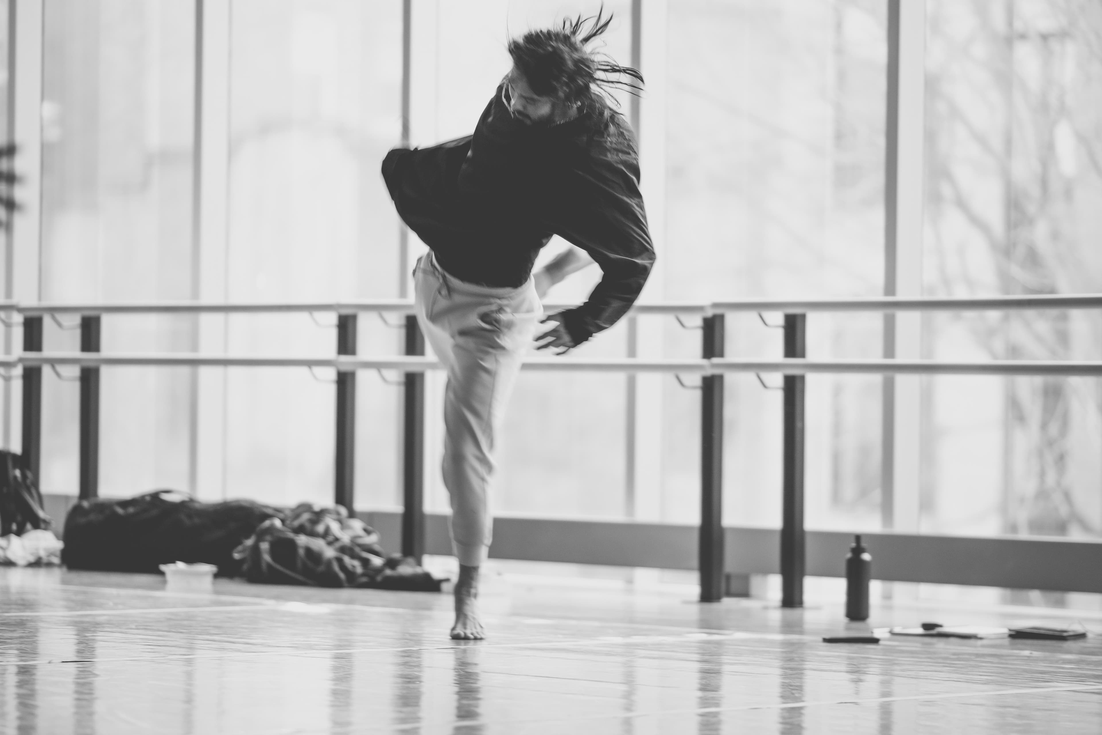 Niki spinning mid-turn in a bright studio, hair flying
