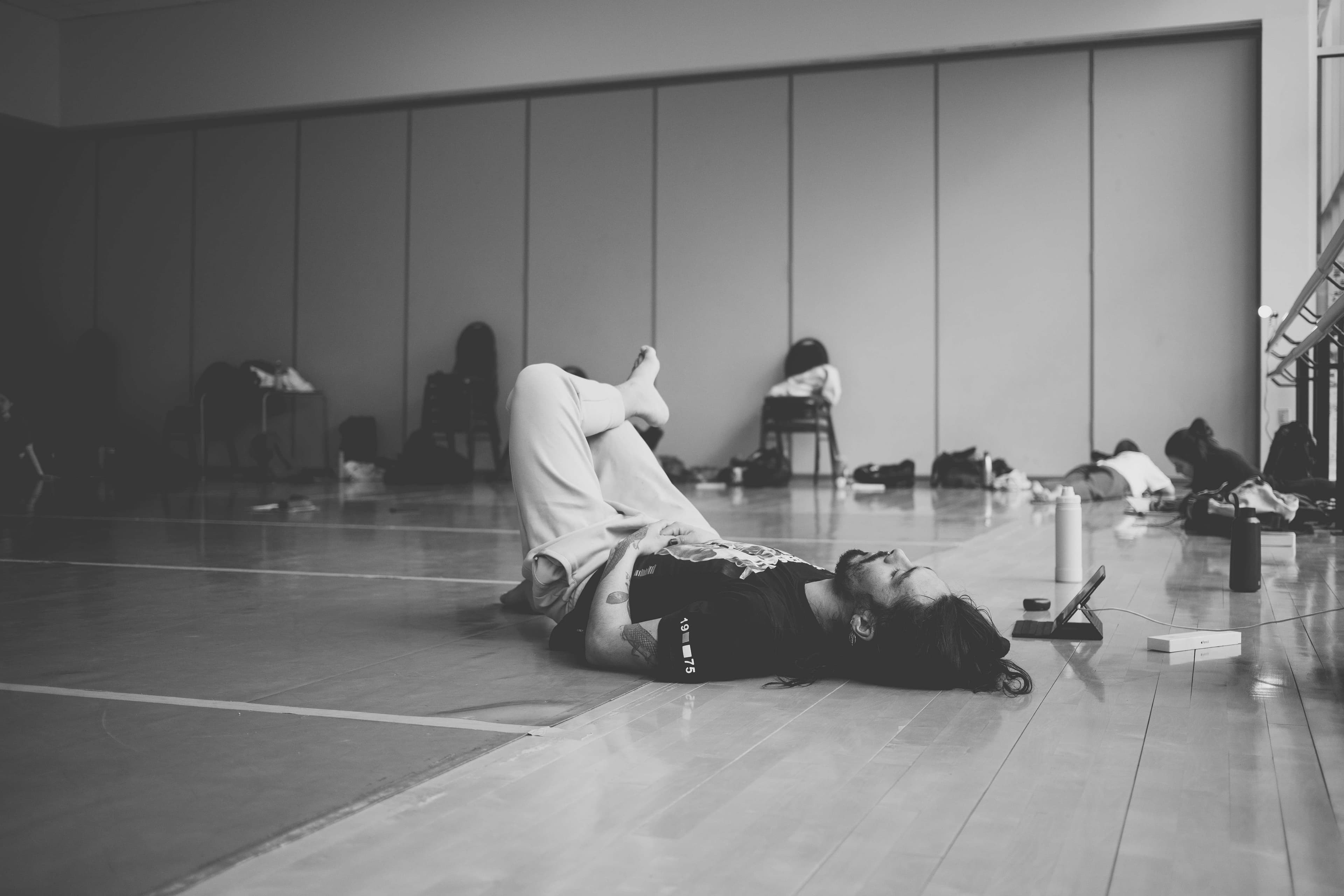 Niki lying on the studio floor with one leg crossed over the other